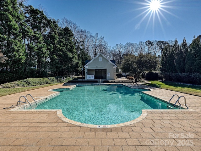 view of swimming pool featuring a patio area and an outdoor structure