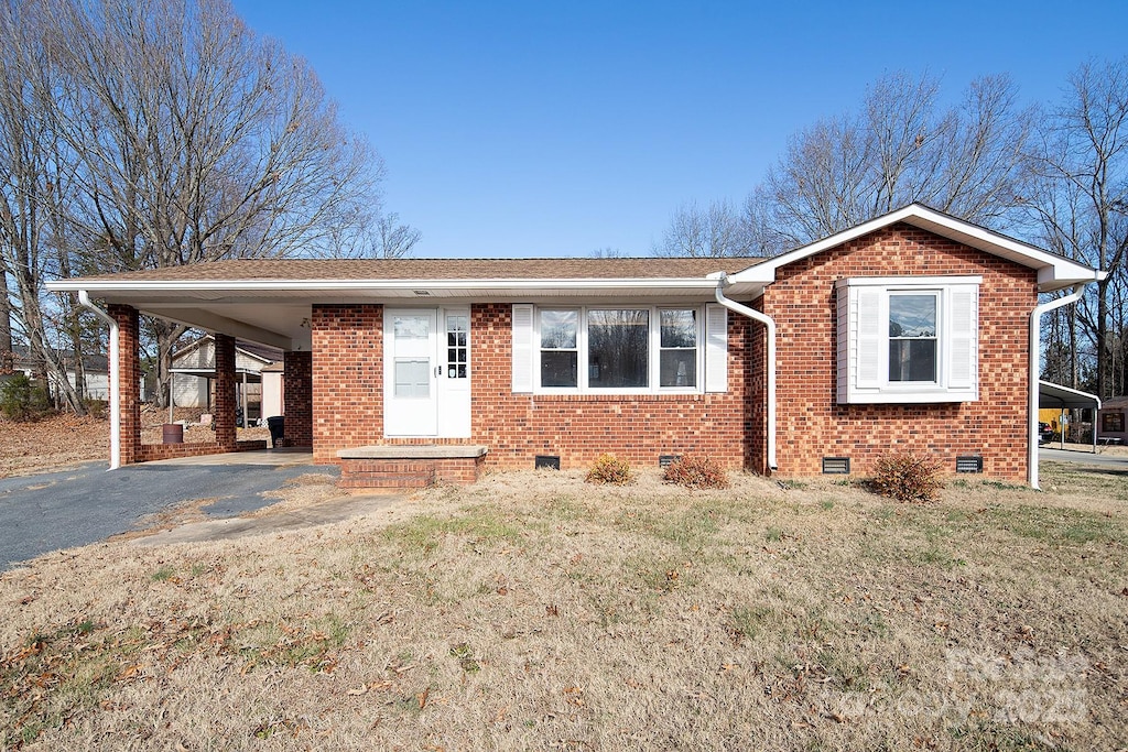 view of front facade featuring a front lawn and a carport