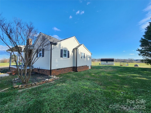 view of home's exterior featuring a lawn and a storage unit