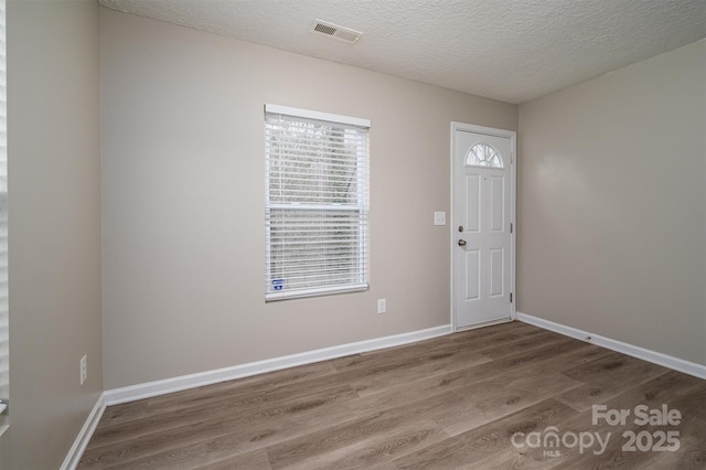 foyer featuring wood-type flooring and a textured ceiling