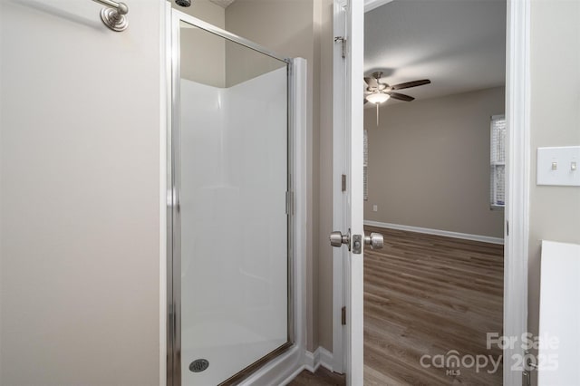 bathroom featuring a shower with shower door and hardwood / wood-style flooring