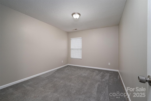 carpeted empty room featuring a textured ceiling