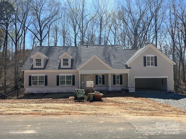 view of front facade with gravel driveway, crawl space, a shingled roof, and an attached garage