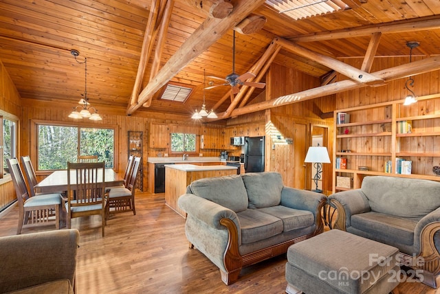 living room featuring beamed ceiling, wood ceiling, and light hardwood / wood-style flooring