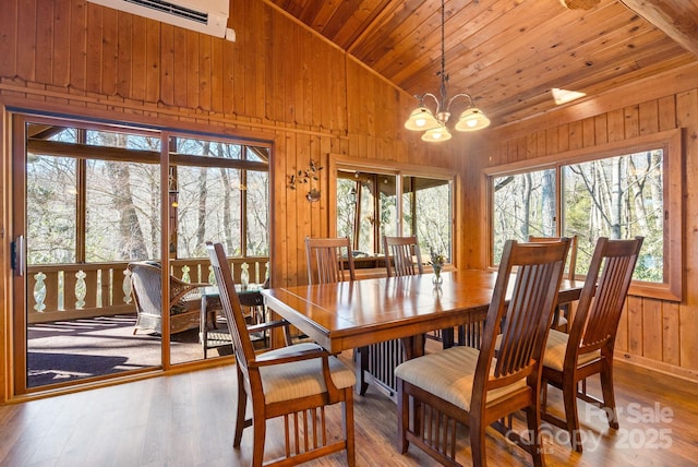 dining room featuring a notable chandelier, wood-type flooring, wood ceiling, and vaulted ceiling