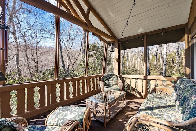 sunroom / solarium featuring lofted ceiling with beams