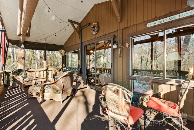 sunroom / solarium featuring lofted ceiling, a wealth of natural light, and track lighting