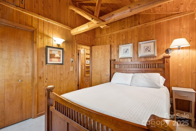 carpeted bedroom featuring beam ceiling, wood walls, and wooden ceiling