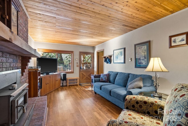 living room with a wood stove, wood ceiling, and light hardwood / wood-style floors