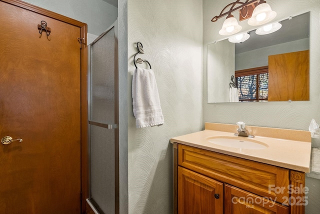 bathroom with vanity, an enclosed shower, and an inviting chandelier