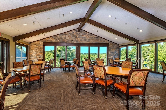 dining room with lofted ceiling with beams and dark colored carpet