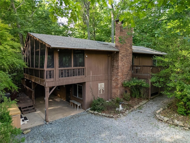 44 Yanequa Way, Brevard, NC 28712 - back of house featuring a sunroom, a patio area, a chimney, a deck, and roof with shingles