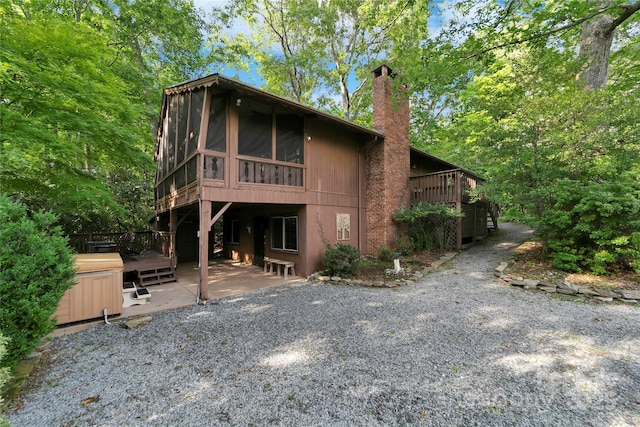 44 Yanequa Way, Brevard, NC 28712 - back of house with a patio, a sunroom, a chimney, a hot tub, and a deck