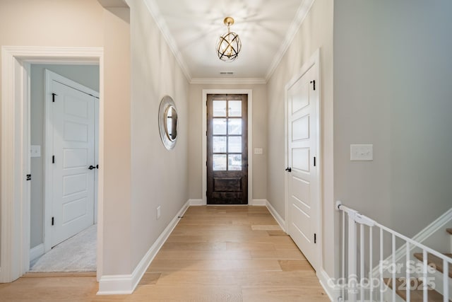 entryway with light wood-type flooring and ornamental molding