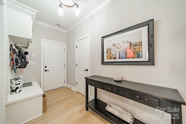 interior space featuring crown molding and light hardwood / wood-style floors