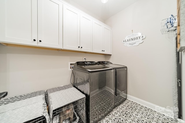 clothes washing area featuring cabinets, light tile patterned floors, and washer and clothes dryer