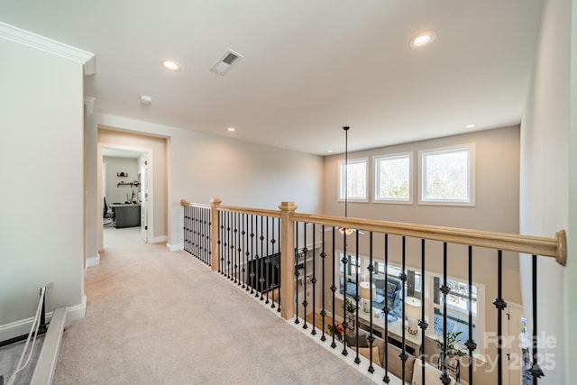 hall with light colored carpet and crown molding