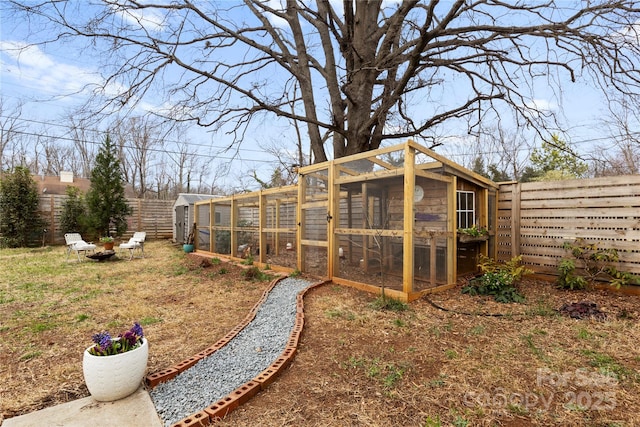 view of yard with an outdoor structure, a fenced backyard, and exterior structure