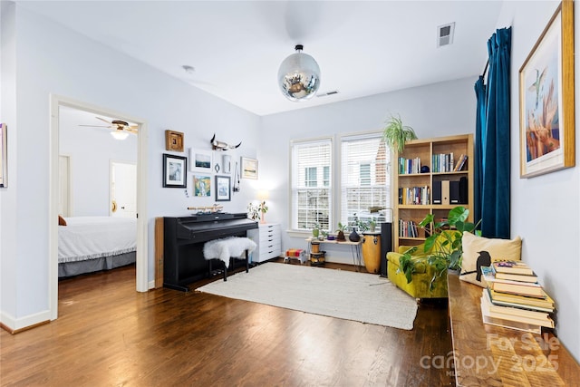 living area featuring visible vents, baseboards, and wood finished floors