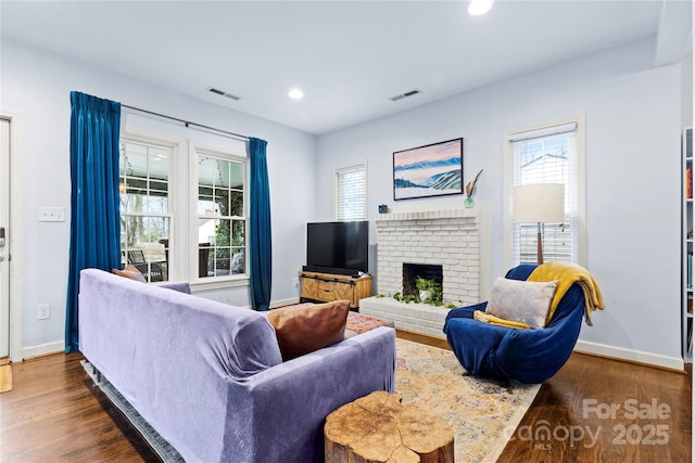 living area with visible vents, plenty of natural light, and dark wood-style floors