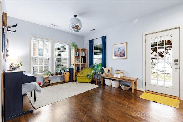 living area with visible vents and wood finished floors