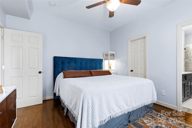 bedroom with dark wood-type flooring, connected bathroom, baseboards, and ceiling fan