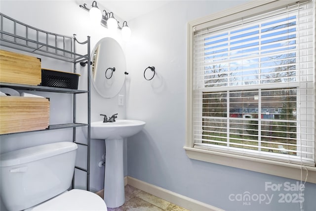 bathroom with toilet and baseboards