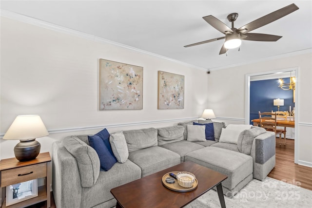 living room with hardwood / wood-style flooring, ceiling fan, and ornamental molding