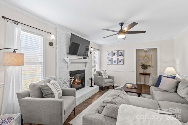 living room with hardwood / wood-style floors, ceiling fan, plenty of natural light, and a brick fireplace