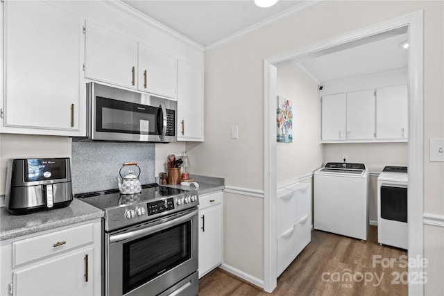 kitchen featuring dark wood-type flooring, crown molding, separate washer and dryer, appliances with stainless steel finishes, and white cabinetry