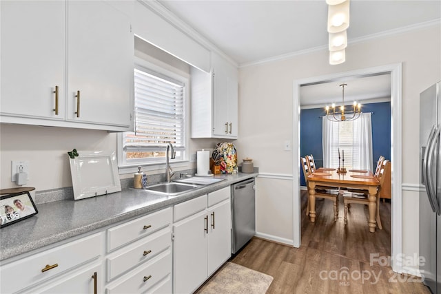 kitchen with white cabinets, appliances with stainless steel finishes, hanging light fixtures, and sink