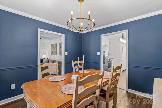 dining space featuring hardwood / wood-style flooring, ornamental molding, and an inviting chandelier