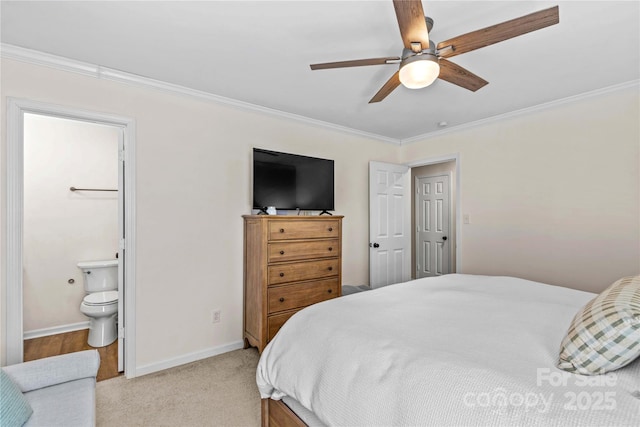 bedroom featuring ensuite bath, ceiling fan, light colored carpet, and ornamental molding