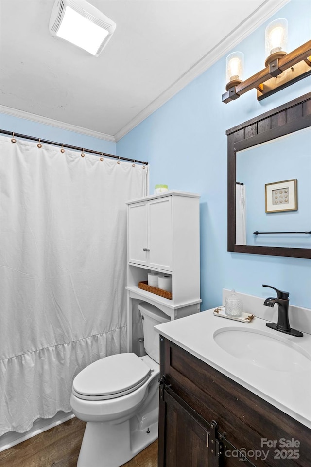 bathroom featuring crown molding, vanity, wood-type flooring, and toilet