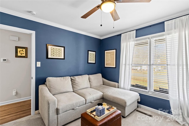 carpeted living room featuring ceiling fan and ornamental molding