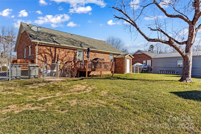 rear view of house with a lawn and a deck