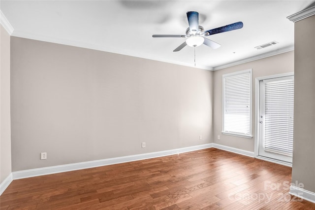 empty room with ceiling fan, crown molding, and wood-type flooring