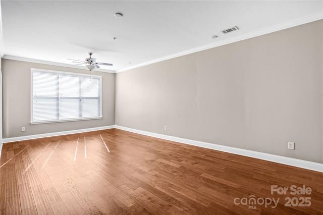 empty room featuring hardwood / wood-style flooring, ceiling fan, and crown molding