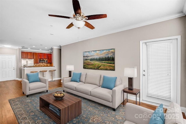 living room with ceiling fan, crown molding, and wood-type flooring