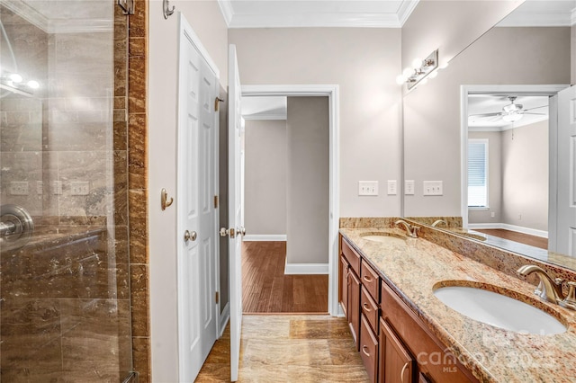 bathroom featuring ornamental molding, ceiling fan, vanity, and a shower with shower door