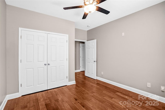 unfurnished bedroom with wood-type flooring, ceiling fan, and a closet