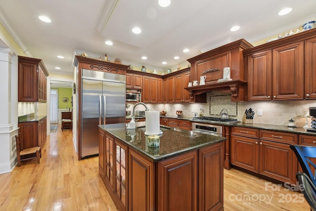 kitchen featuring light hardwood / wood-style flooring, stainless steel appliances, and an island with sink