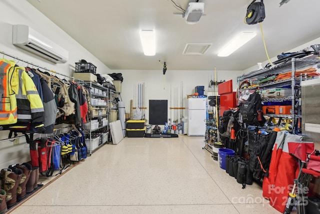 garage with an AC wall unit, white fridge, and a garage door opener