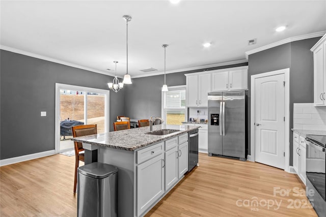 kitchen featuring white cabinets, sink, an island with sink, and appliances with stainless steel finishes