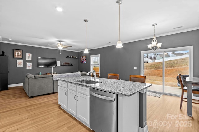 kitchen featuring pendant lighting, sink, stainless steel dishwasher, light stone counters, and white cabinetry