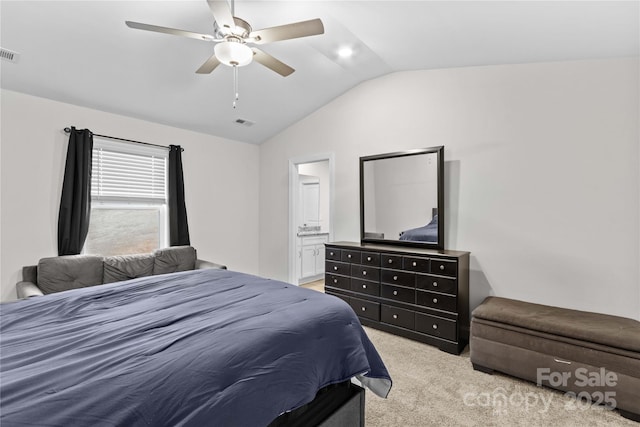 carpeted bedroom with ceiling fan, vaulted ceiling, and ensuite bath