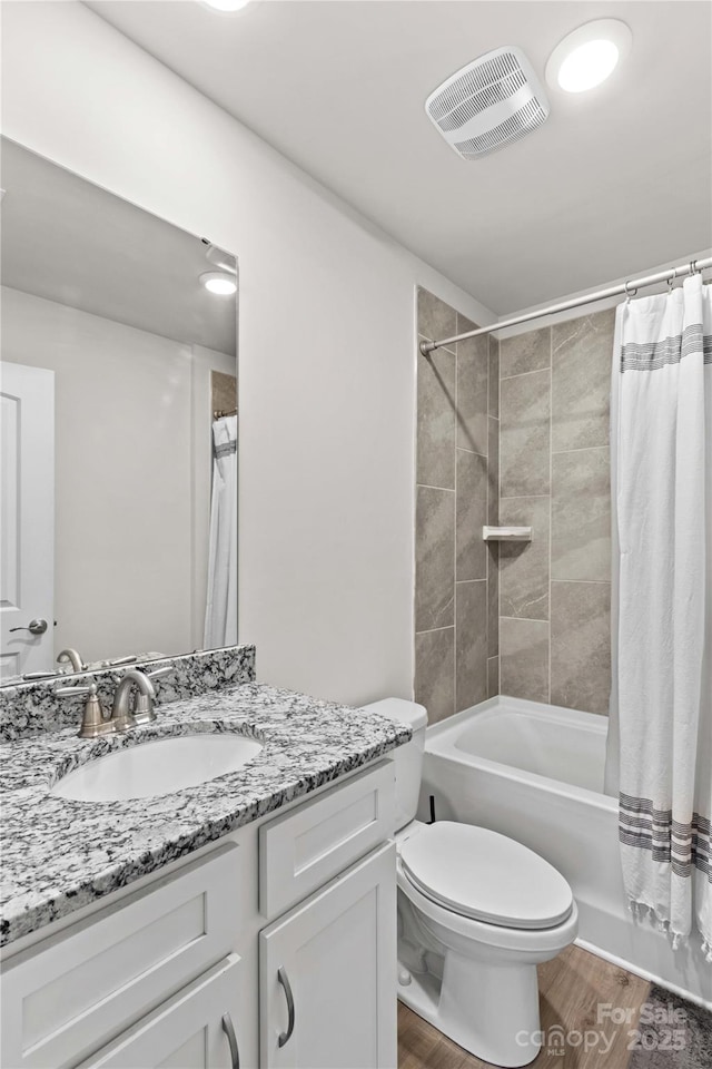 full bathroom featuring hardwood / wood-style floors, vanity, toilet, and shower / bath combination with curtain