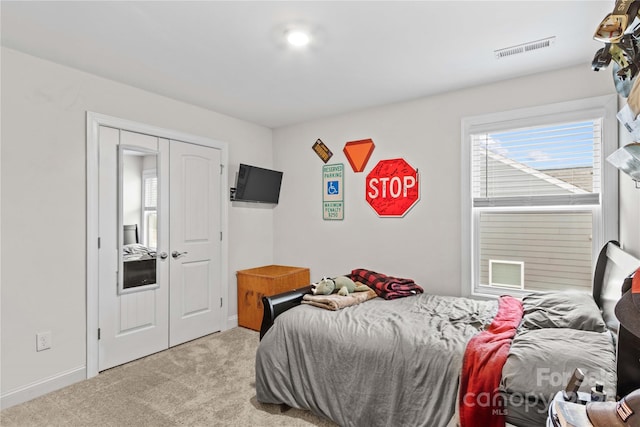 bedroom with light carpet and a closet