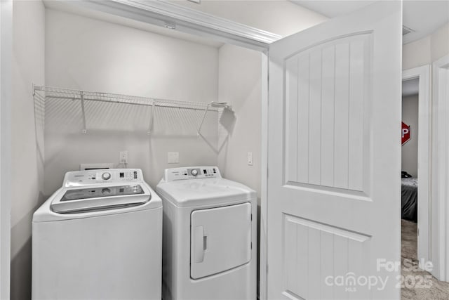 clothes washing area with washer and clothes dryer