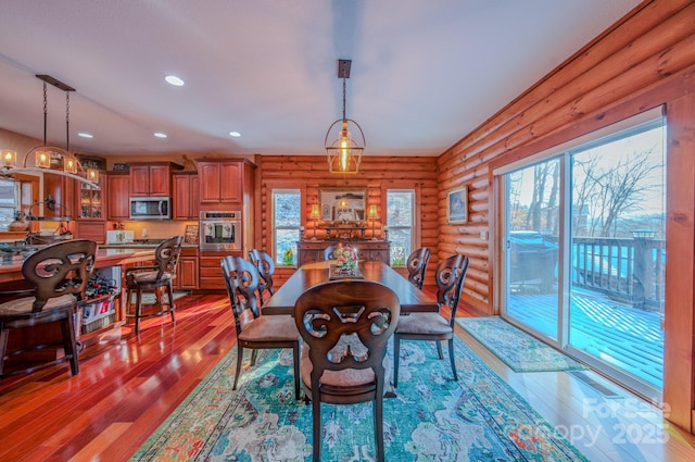 dining space with rustic walls and light hardwood / wood-style floors